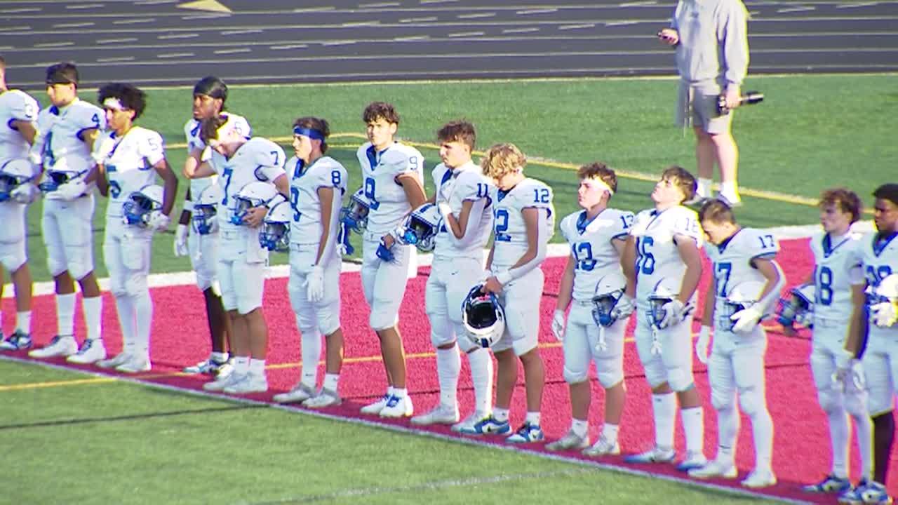 football players lined up during the national anthem