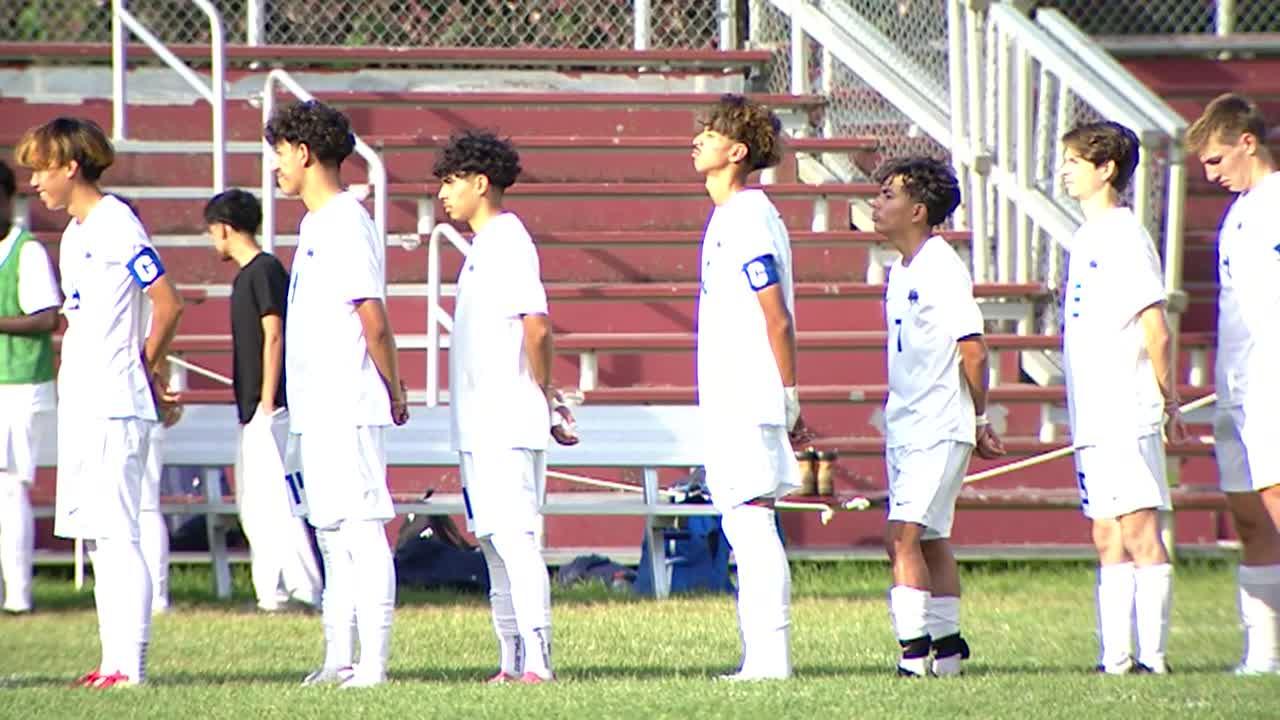 soccer players standing for the national anthem