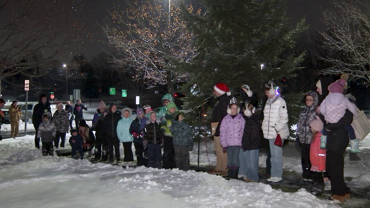 group of people standing in front of christmas tree