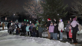 group of people standing in front of christmas tree