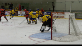 hockey players passing puck in front of goalie