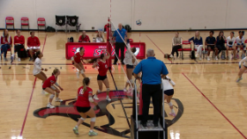 volleyball players hitting ball over the net