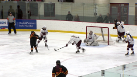hockey player taking a shot on goal while surrounded by defenders