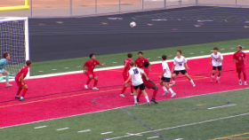 soccer players in a group trying to make a goal